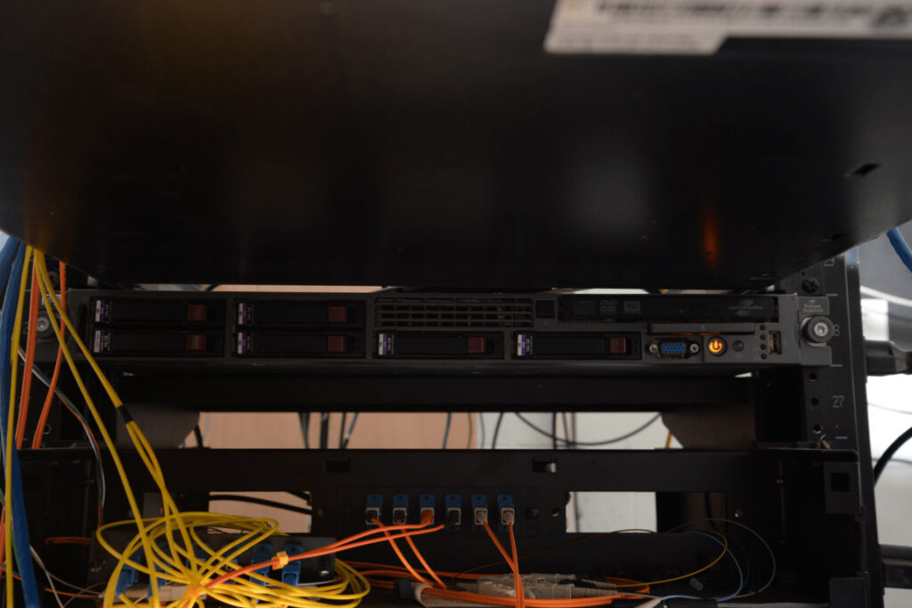 EFTA00002518 - Server rack with multiple hard drives and network cables connected in a data center environment